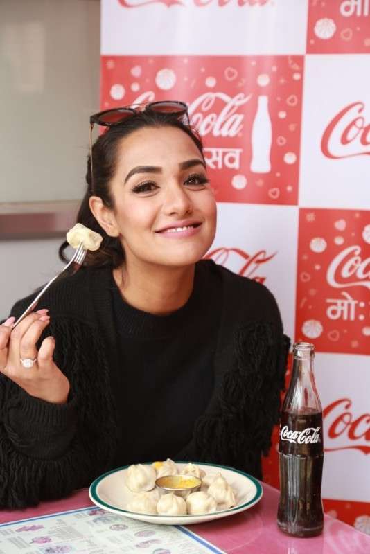 This handout photo shows actress Priyanka Karki having a delightful moment with Coke and mo:mo during the Coca-Cola Mo:motsav. 