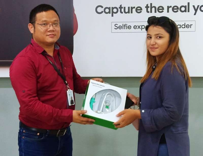 Representative of OPPO (L) hands over prize to one of the winners of its selfie contest amid a function in the capital on Sunday. Photo Courtesy: OPPO