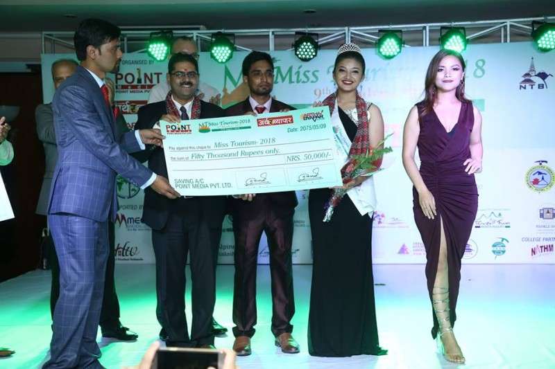 This handout photo provided by the organisers of Miss Tourism shows Manita Poudel of Bhaktapur receiving a cheque of Rs 50,000 upon winning the title of Miss Tourism-2018 on Saturday. She also won Miss Photogenic title.