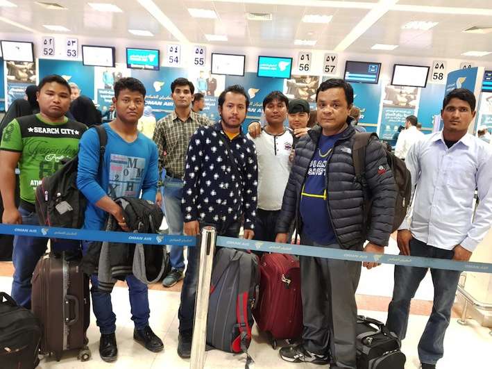 This handout photo provided by Muscat-based Nepali embassy shows eight Nepali workers who were stranded in Oman before being  returned safely to Nepal.
